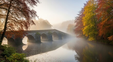 An ancient stone arch bridge spans a misty river, reflecting vibrant autumn foliage during the morning sunrise.