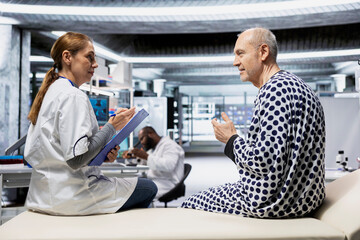 Confident woman doctor consulting vitals of senior patient in research lab, evaluating and monitoring potential allergies and side effects during drug testing procedure. RD institute for innovation.