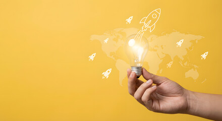hand holding glowing light bulb with rocket launch idea