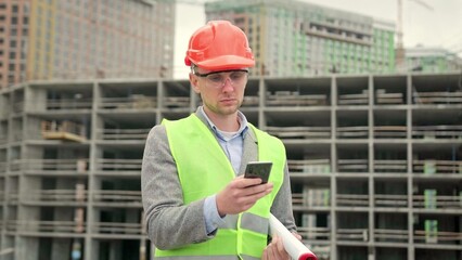 Foreman reading something on smartphone on building site