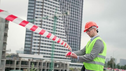 Foreman cordoning off new development site for safety purposes