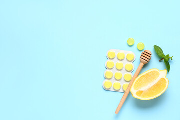 Cough drops in blister with lemon, dipper and mint leaves on blue background