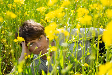 Frau zwischen gelben Bl&uuml;ten im Rapsfeld