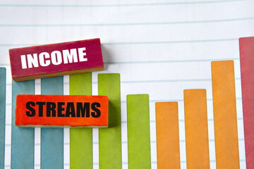 INCOME STREAMS - words on wooden blocks against the background of colorful graphics