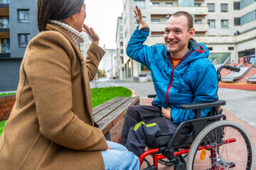 Disabled man in wheelchair sharing high five with friend