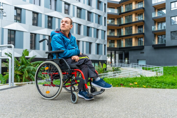 Disable adult in wheelchair looking away in modern urban setting