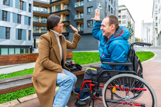 Man with disability giving high five to female caregiver