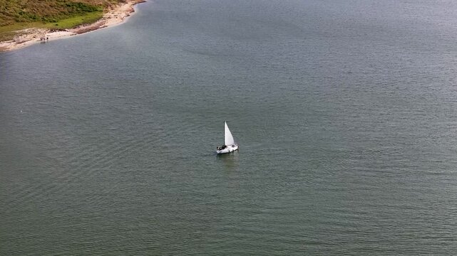 Punto de inter&eacute;s a un velero que navega en la laguna de Tomin&eacute;, llegando a la costa, en Cundinamarca, Colombia.