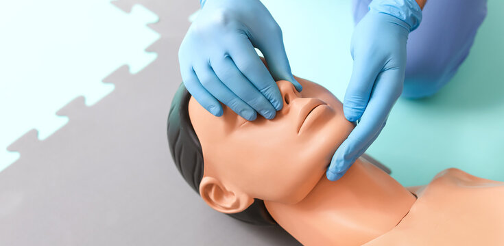 Instructor demonstrating CPR on mannequin at first aid training course