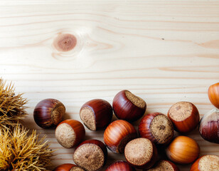 Several chestnuts on a light wooden table. Ai