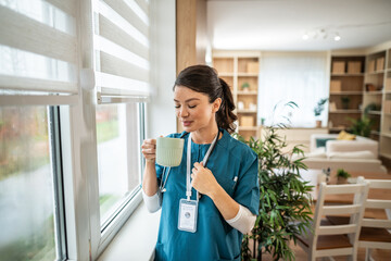 Nurse relaxing during break, drinking hot beverage
