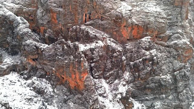 A dramatic aerial view of snowy rocky cliffs and rugged winter mountain terrain in Munzur Valley. Ideal for nature, geography, winter landscapes and cinematic drone footage.