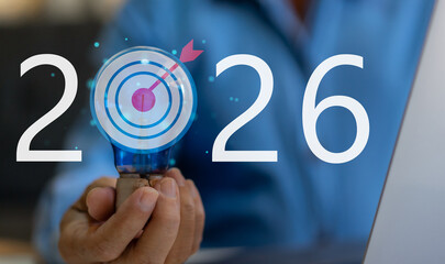 Businessman hold light bulb with target icon 2026, Concept for creative idea innovation, strategic vision, marketing goal setting and planning future business success objective, corporate development