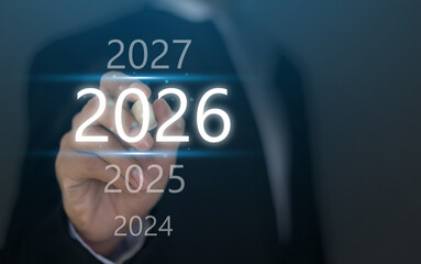 Businessman hand touching 2026 on digital virtual screen interface, Concept of new year business planning, financial strategy corporate goal, future vision, economic forecast and management success