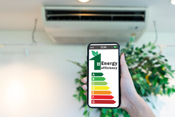 Smartphone Showing Energy Efficiency Rating with Air Conditioner Background for Green Home Savings