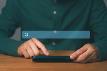 Young man using a smartphone with a search bar, representing online browsing, social media, news, searching products and services, SEO, data research, and internet information discovery at home.