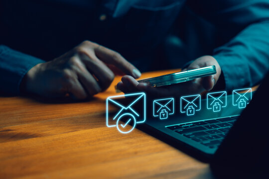 Secure email and cybersecurity concept. Person using smartphone and laptop with glowing blue hologram icons of encrypted messages, verified mail, and digital data protection. - Powered by Adobe