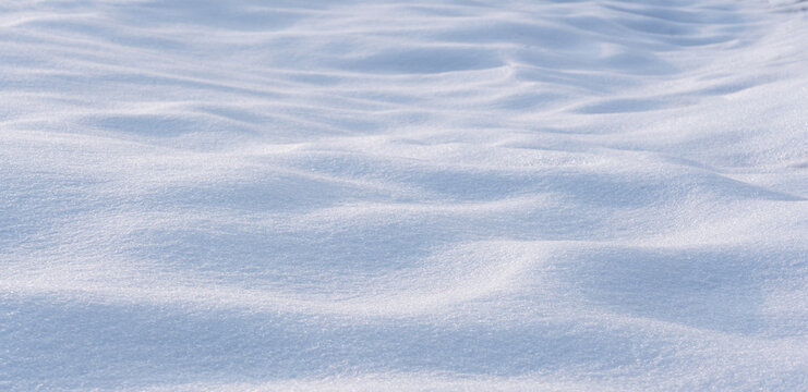 Winter background with snow-covered wavy uneven ground surface,