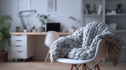 Cozy chair with a knitted blanket in a modern workspace during daytime