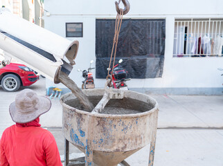 A complete construction sequence showing a cement mixer truck loading wet concrete into a crane-suspended bucket