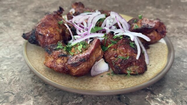 crispy grilled chicken wings on plate, topped with thinly sliced red onion and parsley, charred edges glazed with smoky marinade, rustic stone surface, closeup foodporn shot