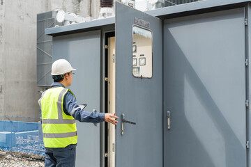 Obraz premium Engineer opening protection control cabinet at high voltage substation