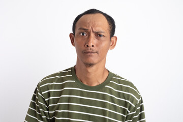 A serious man wearing a green shirt with white stripes gazes intensely at the camera, showing a stern expression. 