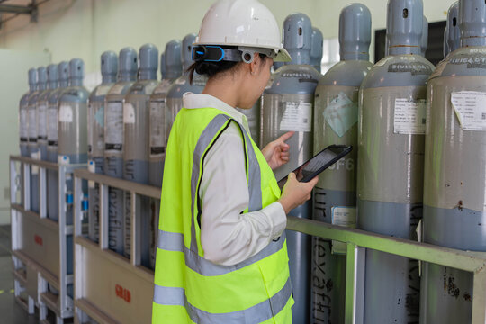 Engineer verifying SF6 gas cylinder labels using tablet to track inventory status, ensure safety compliance, and support accurate asset management in industrial facility