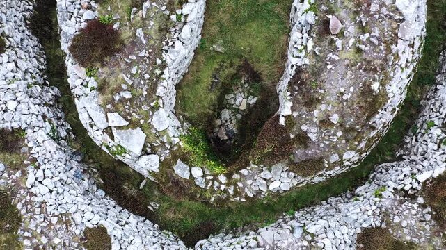 Carn Gluze aka Ballowall Barrow. St. Just, Cornwall. Bronze Age prehistoric funerary cairn chambered tomb mound and multiple stone cists. Altered by modern reconstruction. Aerial video fly up from cen