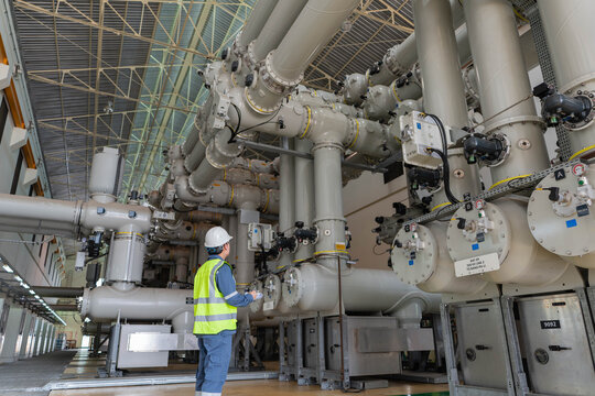 Power engineer verifies gas insulated switchgear maintenance status, checking valves and connections to confirm system integrity, operational safety, and reliable substation performance.