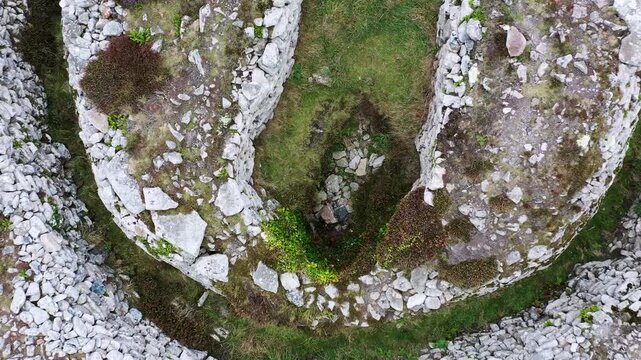 Carn Gluze aka Ballowall Barrow. St. Just, Cornwall. Bronze Age prehistoric funerary cairn chambered tomb mound and multiple stone cists. Altered by modern reconstruction. Aerial video fly up from cen