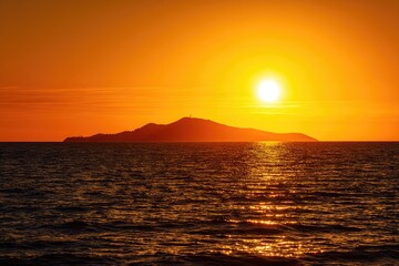 Fiery sunset over a calm ocean, silhouetting a distant island