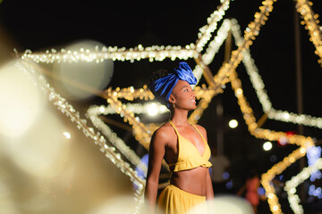 Young woman enjoying vibrant night out with festive lights
