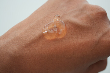 Fototapeta premium Clear aloe vera gel on skin in close-up view during daylight