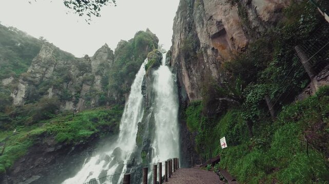 Brizas waterfall surrounded by cliffs and vegetation in Zacatl&aacute;n, Mexico