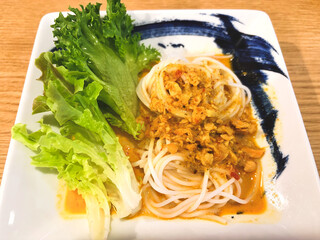 Rice noodles with salmon curry in the white plate 