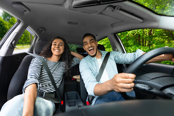 Emotional millennial couple enjoying journey by auto, shot from automobile dashboard, copy space....