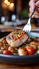 Person holding fork with a piece of seared fish