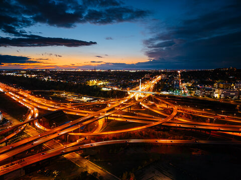 Aerial night view of Turcot Interchange in Montreal with glowing highways and city lights at dramatic blue hour. g.