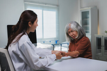 Obraz premium Doctor examining senior woman experiencing arm pain