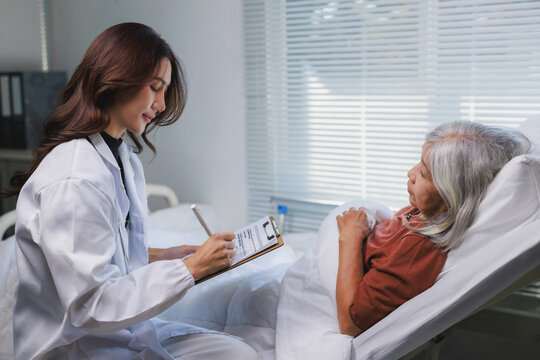 Doctor taking notes while consulting senior patient