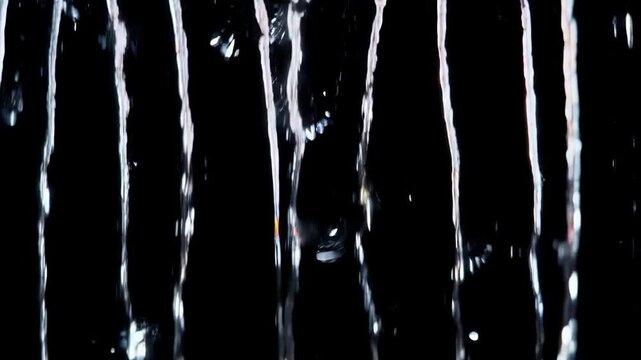 Abstract Water Streams Flowing Downward Against a Black Background, Dynamic Motion.