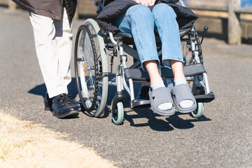 車椅子を押して散策をする親子