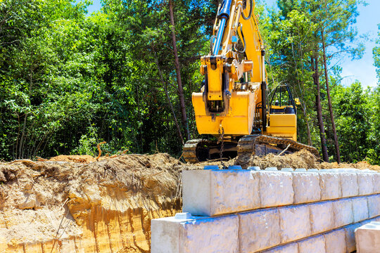 Excavator working on construction site creating retaining wall
