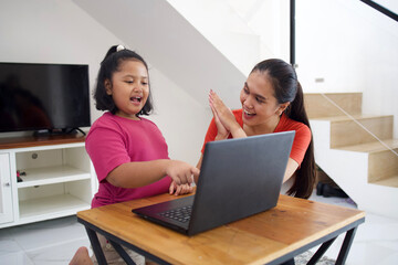 Obraz premium Asian mother and kid with laptop for e-learning, online education and studying, laughing and having fun at home.