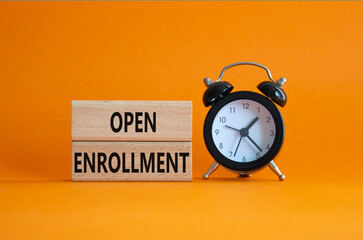 Open Enrollment symbol. Wooden blocks with words Open Enrollment. Beautiful orange background with alarm clock. Business and Open Enrollment concept. Copy space.