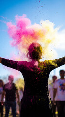 Silhouette of a woman celebrating Holi festival with colorful powder explosion. Happy person with arms raised throwing pink and yellow paint dust outdoors. Freedom and joy concept