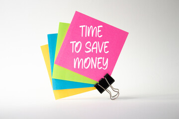 Time to save money symbol. Pink sticky note with paper clips with words Time to save money. Beautiful white background. Business and Time to save money concept. Copy space.