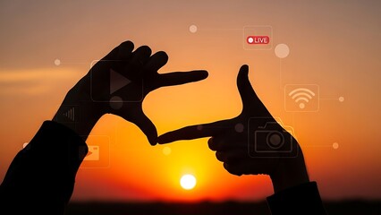 Silhouette of giraffe and hand holding camera at sunset