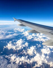 Obraz premium Aerial view from an airplane window, showing wing and fluffy clouds